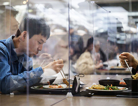 (Hyundai Capital employees having lunch over plastic barriers/Ed Jones/AFP/Gettyimages)